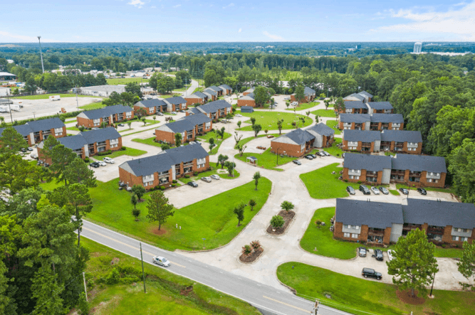 A view of a residential area with lots of green grass.