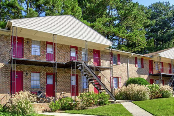 A brick building with stairs leading to the front door.